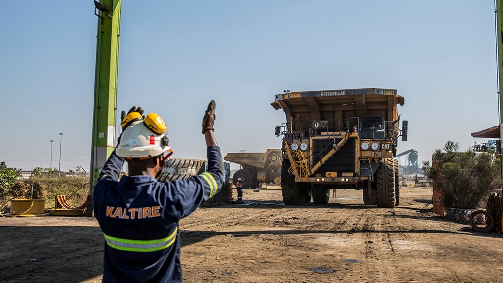 Image of a worker directing a mining truck