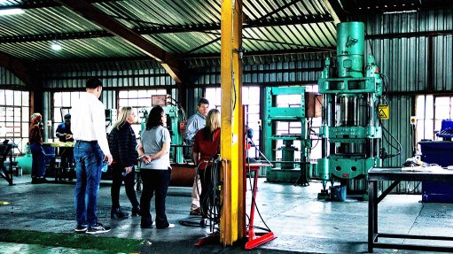 An image depicting people at an AFS launch function in the company's hydraulic press room