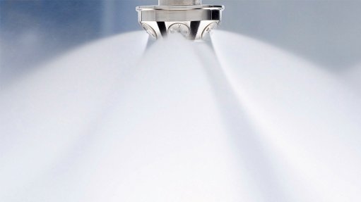 A spray nozzle affixed to a ceiling spraying a large amount of mist water as a fire suppression system offered by Danfoss Fore Safety