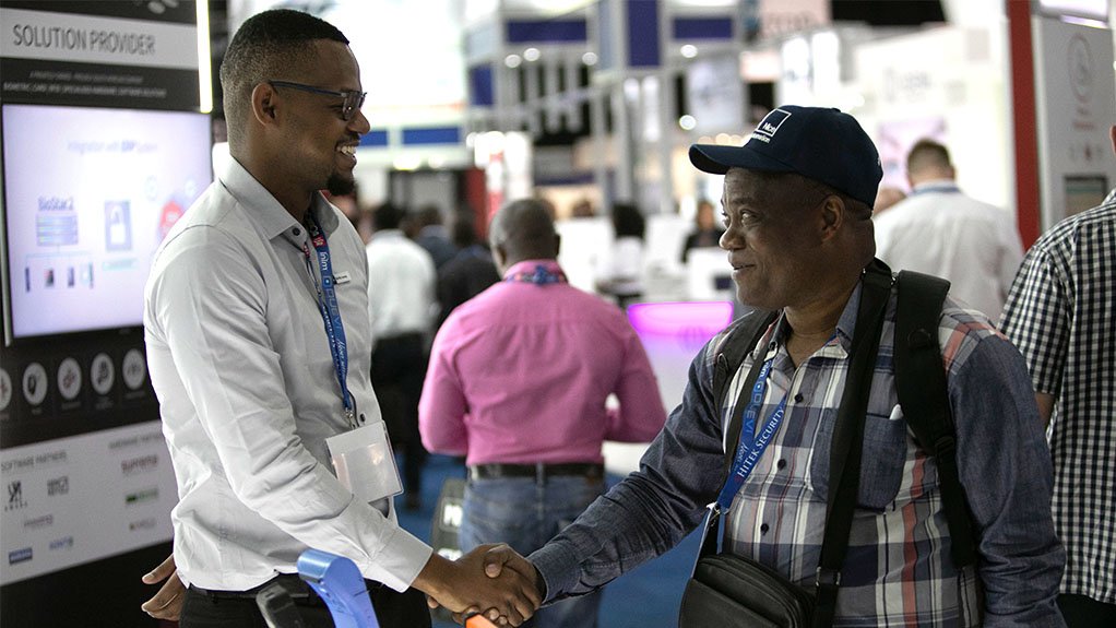 A picture of two gentlemen shaking hands at a branded stand at an event hosted by event organizer Specialised Exhibitions