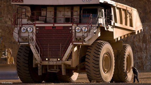 Image shows a mining dump truck and worker