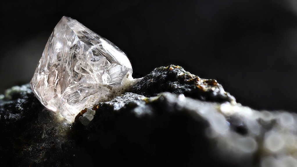 A large uncut diamond on a bed of black kimberlite from a mine in Botswana