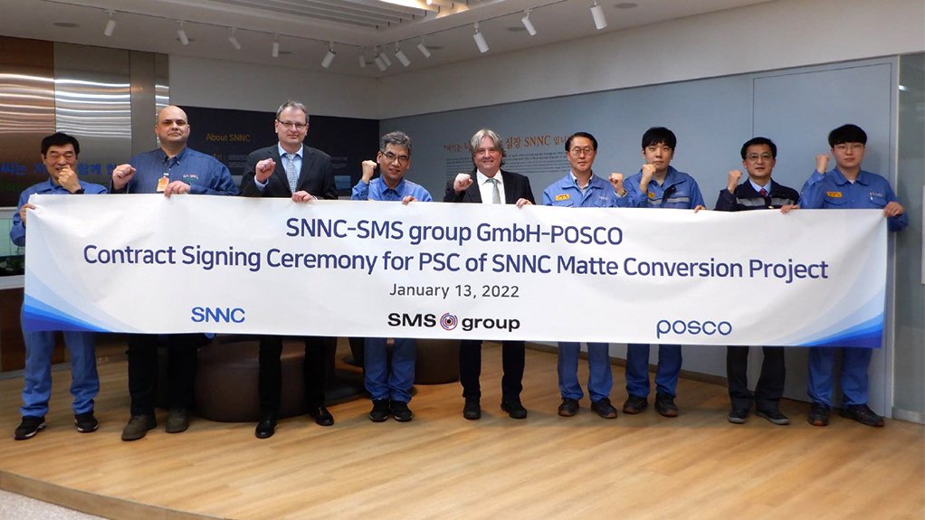 A group of gentlemen representing furnace component manufacturer and SMS group and nickle exporter SNNC holding a sign announcing the conclusion of their contract signing meeting