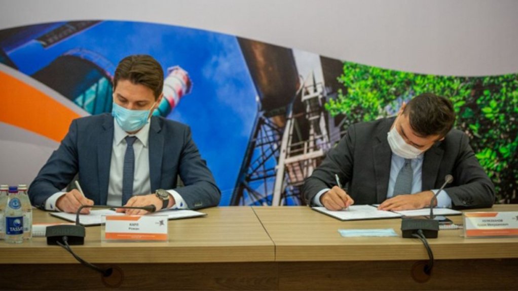 Two men in suits sitting at a table signing the documentation for the or the supply and replacement of four electric filters between thussenkrup and Eurasian Resources Group