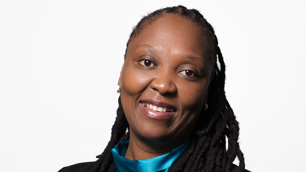 An image depicting a smiling woman, Tshepo Kgare, wearing a blue blouse and black blazer