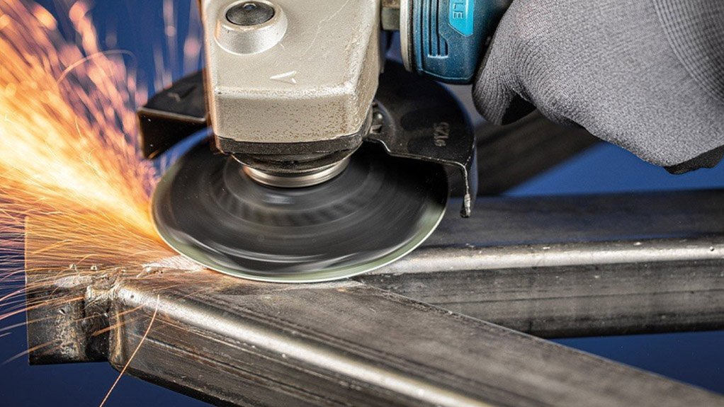 A small cutting disk on an angle grinding a piece of steel with sparks flying to the side