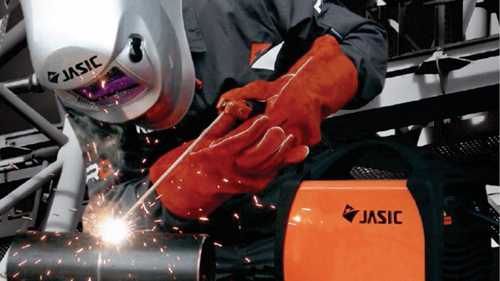 A Jasic branded welding machine with a Jasic welding mask being used by a BMG welder with sparks flying