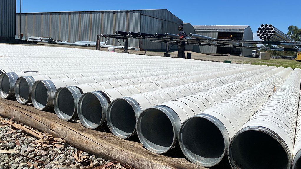 Rows of long white pipe waiting to be coated prior to a water plant installation