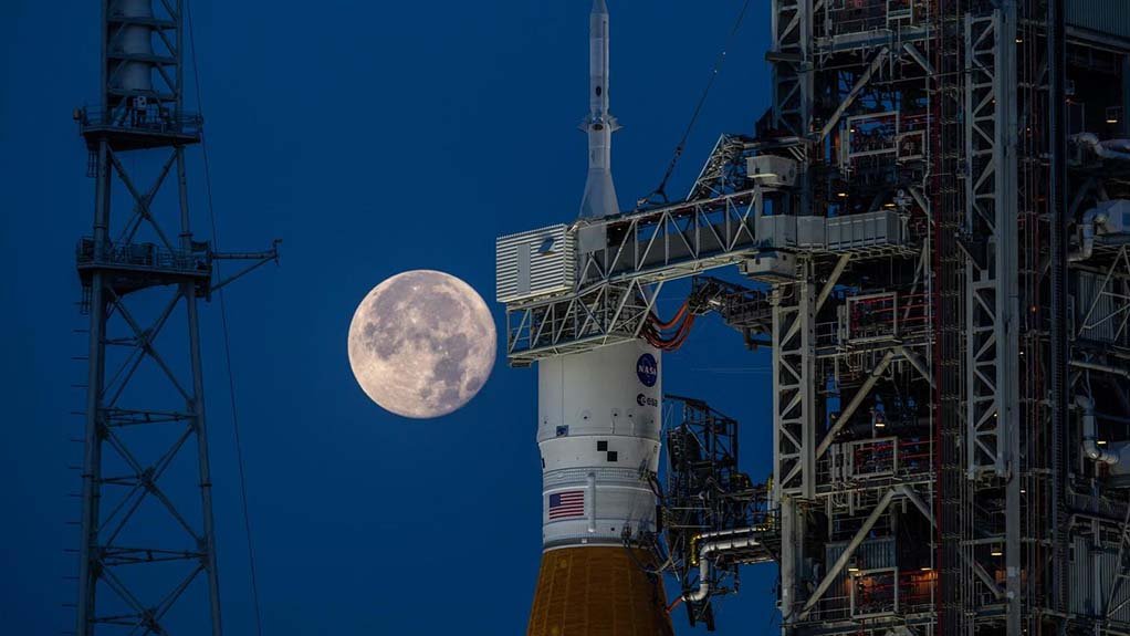 The Orion spacecraft on top of the Space Launch System rocket on the launch pad, with the ESM in the centre of the photo, immediately under the gantry.