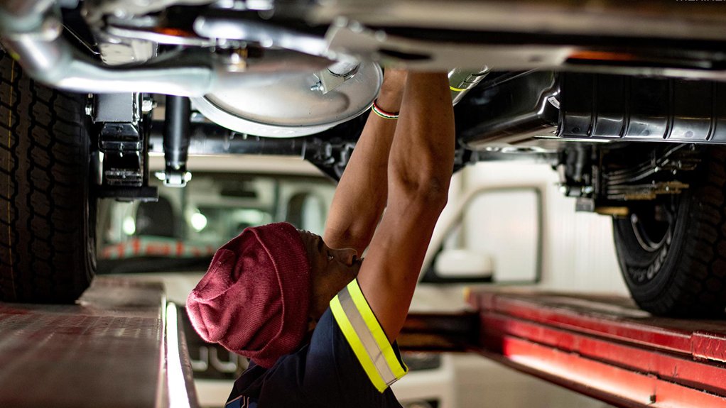 A Mahindra employee working on a Pik Up vehicle