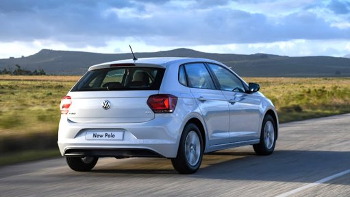 A new white VW Polo being driven through a scenic area