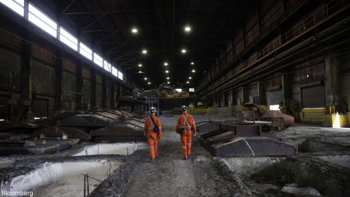 Workers walk between cooling ingots of Bessemer matte at the Vale Copper Cliff Smelter Complex in Sudbury, Canada.