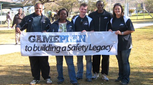 An image depicting men and women holding up a banner that reads 'gameplan to building a safety legacy'