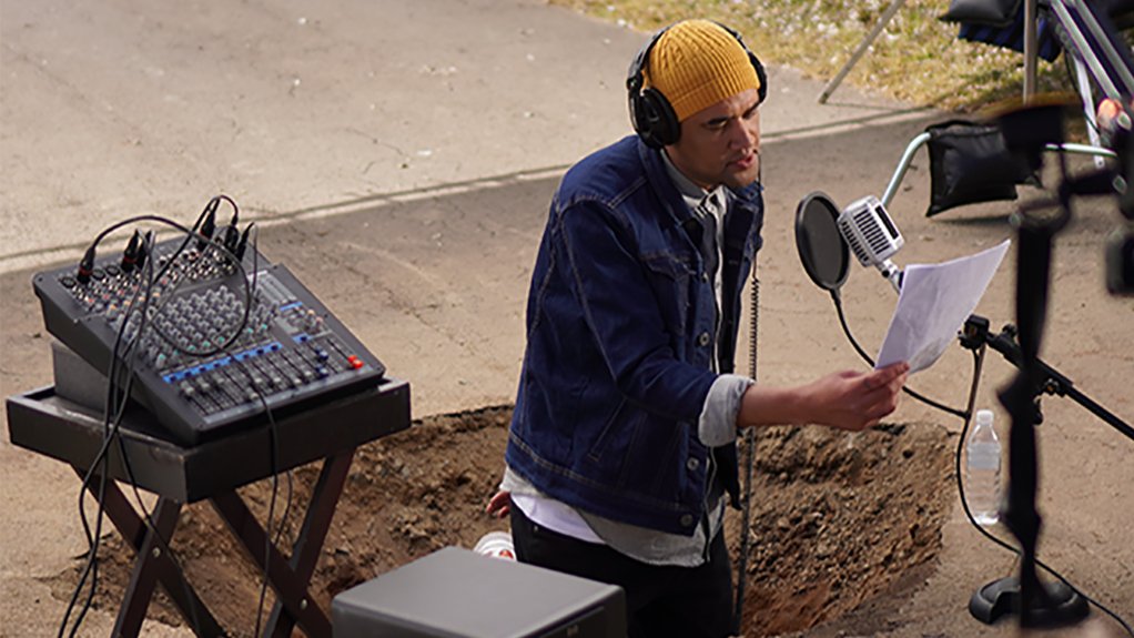 Image of a local comedian Robby Collins presents “Pothole FM” from inside a pothole on a Howick, KZN street, to showcase the confidence needed to drive on SA roads