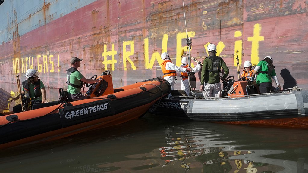 Image shows activists on boats next to a cargo vessel