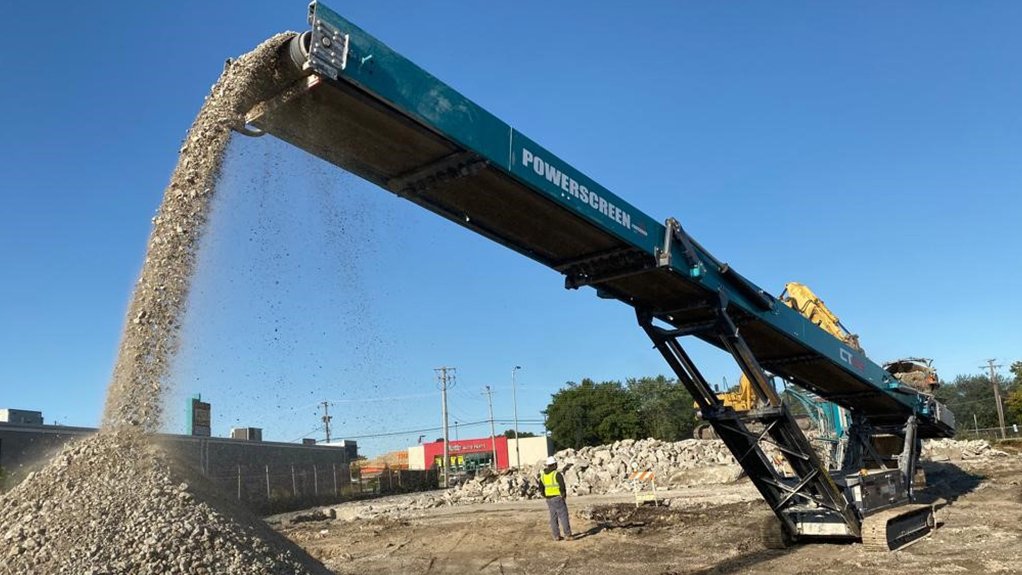 A large conveyor driven screening apparatus pouring material off the end