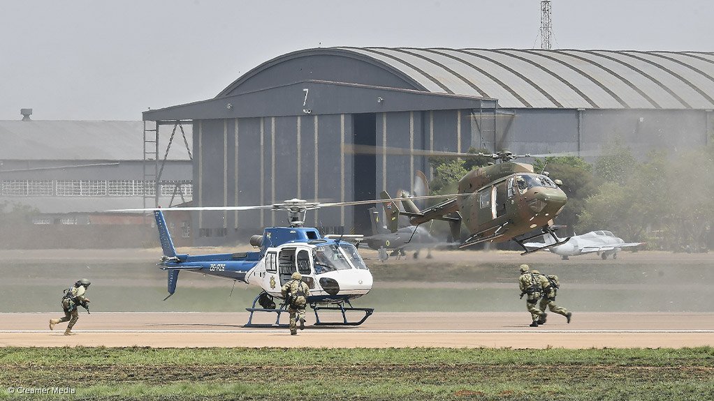 ON THE MOVE: Special forces from the South African Police Service and South African Defence Force (SANDF) move towards a H125 helicopter during an antiaircraft-hijacking demonstration at the Waterkloof Air Force Base, near Pretoria. The demonstration took place during the Africa Aerospace and Defence (AAD) Expo 2022 in September. A South African Air Force BK117 is also seen preparing to collect SANDF special forces personnel who took part in the manoeuvre. The AAD expo was last held in 2018 before being disrupted by the Covid-19 pandemic. Photograph: Creamer Media Chief Photographer Donna Slater
