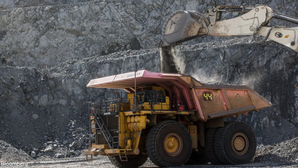 An image of an excavator and a truck in a mine