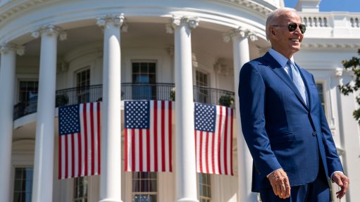 An image of US President Joe Biden standing in front of the White House 