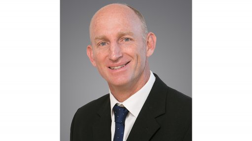 An image depicting a smiling man, Dr Dave Knight, wearing a suit and tie