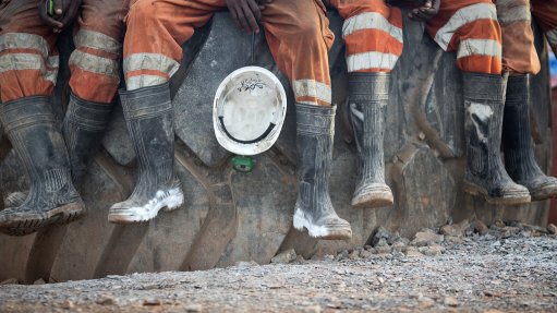 mine workers sitting with rubber gumboots