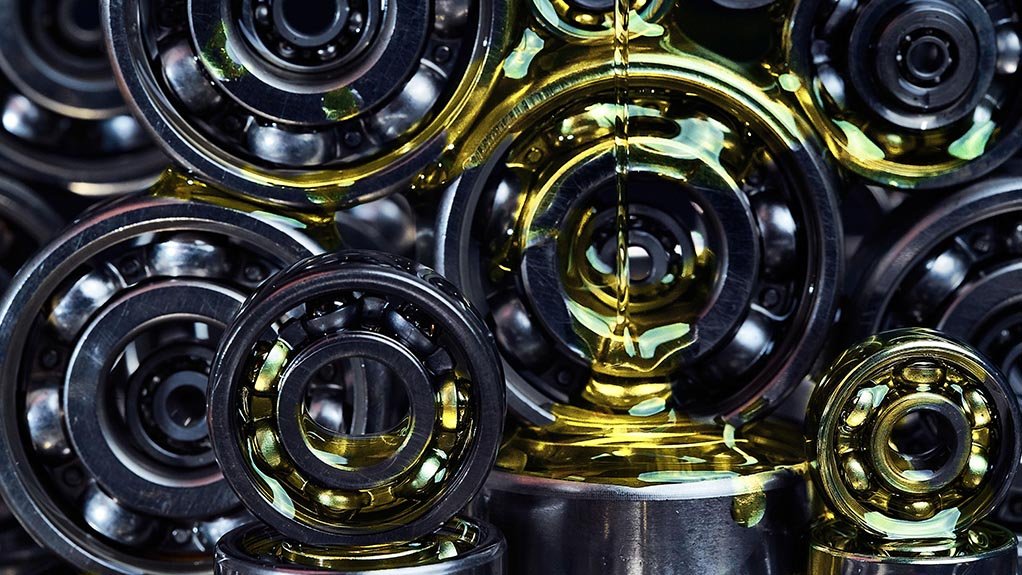 A pile of bearings stacked together with oil being poured over them for a visual shot