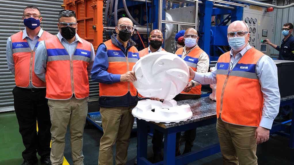 Image of staff at Weir Minerals’ replicast plant, holding a mould made from expanded polystyrene beads 

