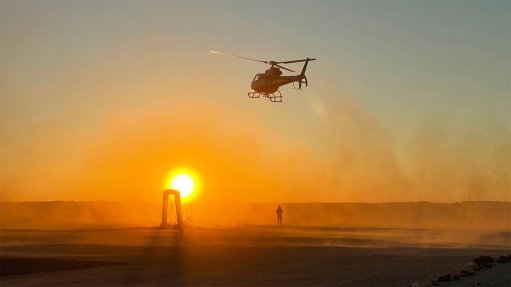 A sunset picture of a helicopter kicking up dust above the Elevate uranium mine in Namibia 