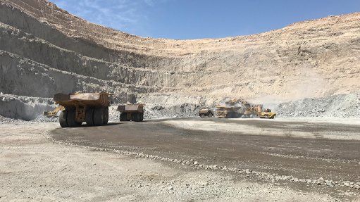 A large openpit uranium mine in Namibia with mine trucks moving ore to the processing facility 