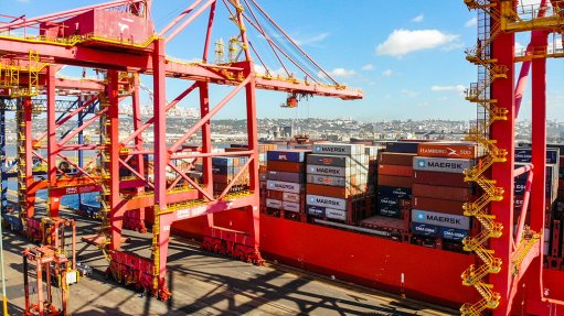 Image of red crane equipment at South African port loading containers on or off a ship.