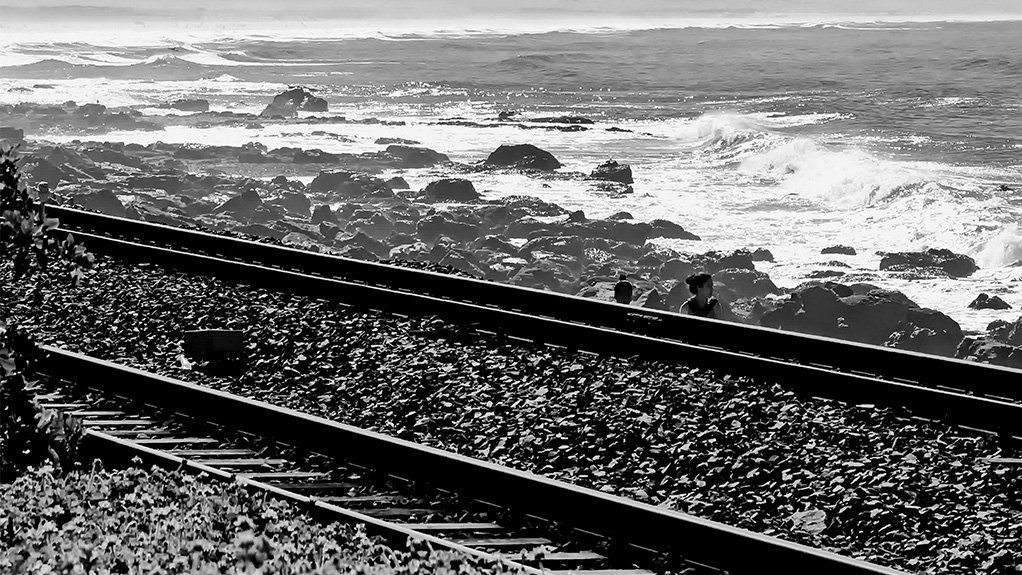 Black and white image of train track along coastline