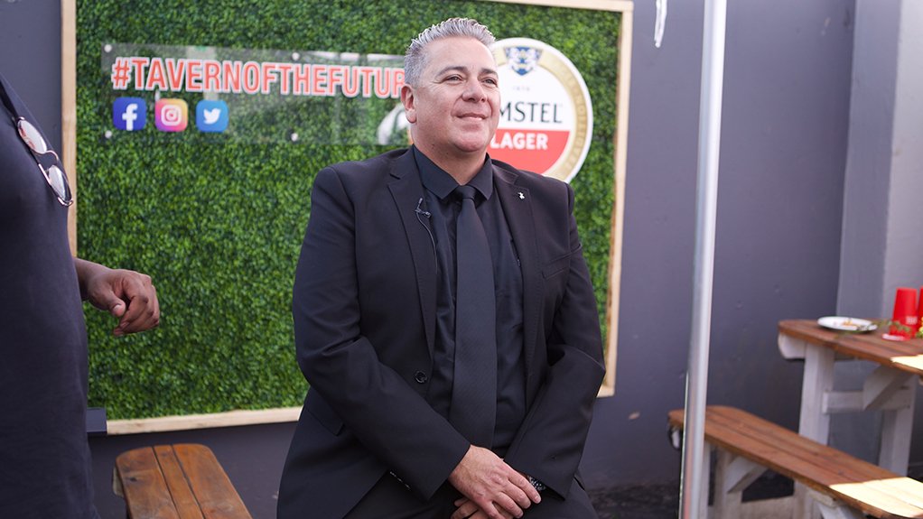 A photo of Heineken South Africa GM Burton Swain in front of a plant wall with Taverns of the Future branding on it