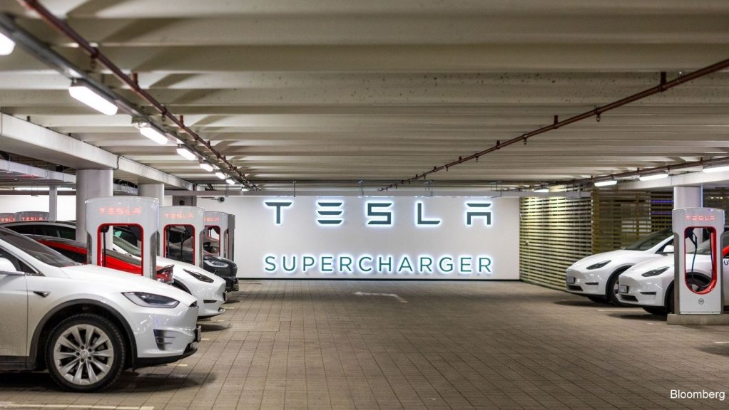 Electric vehicles charge at Tesla supercharger points.