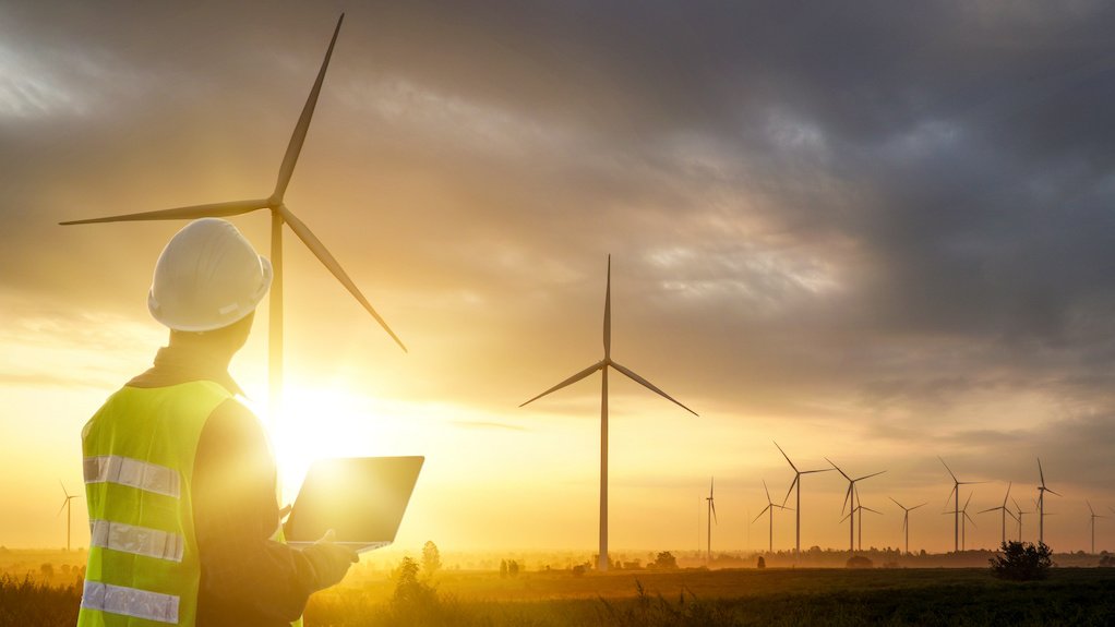 Image of man standing in front of wind turbines