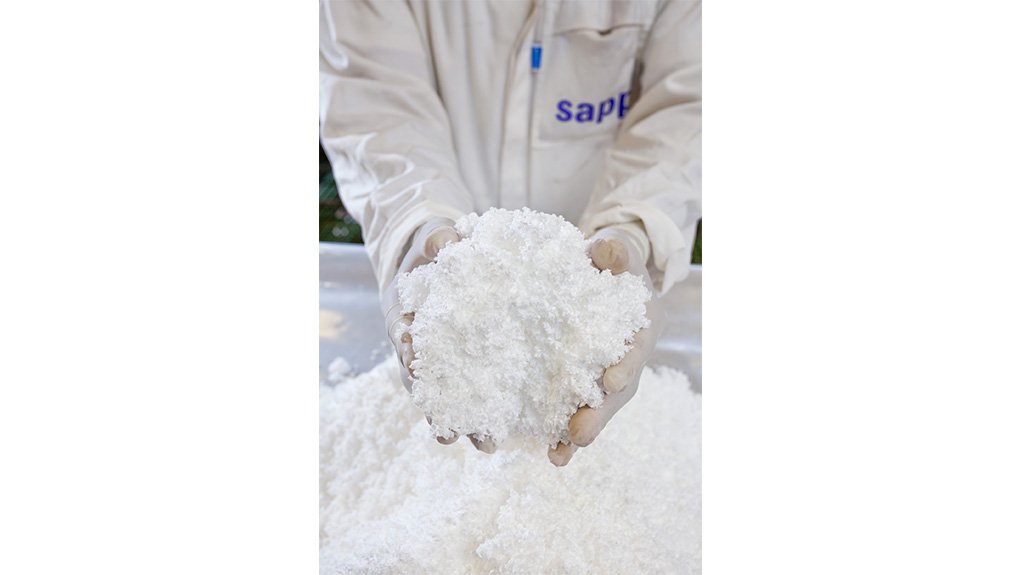 A person in white Sappi coat holding two handfuls of white dissolving pulp