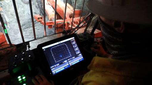 Image of An operator programming the Sandvik DD422i drill rig machine ahead of a blast underground