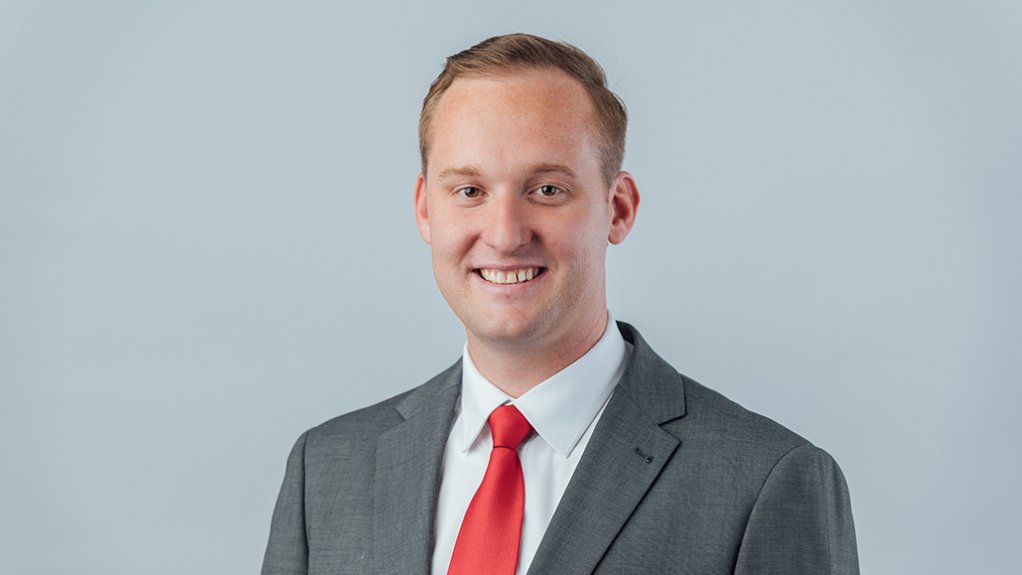 Ruben de Beer in grey suit and red tie, smiling