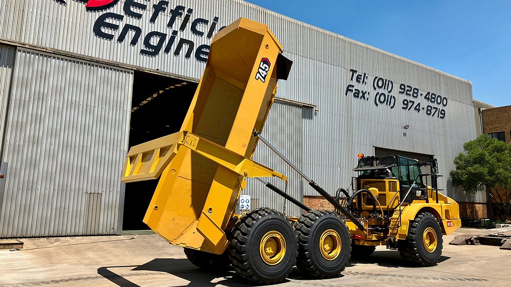 Yellow dump truck outside Efficient Engineering manufacturing facility.