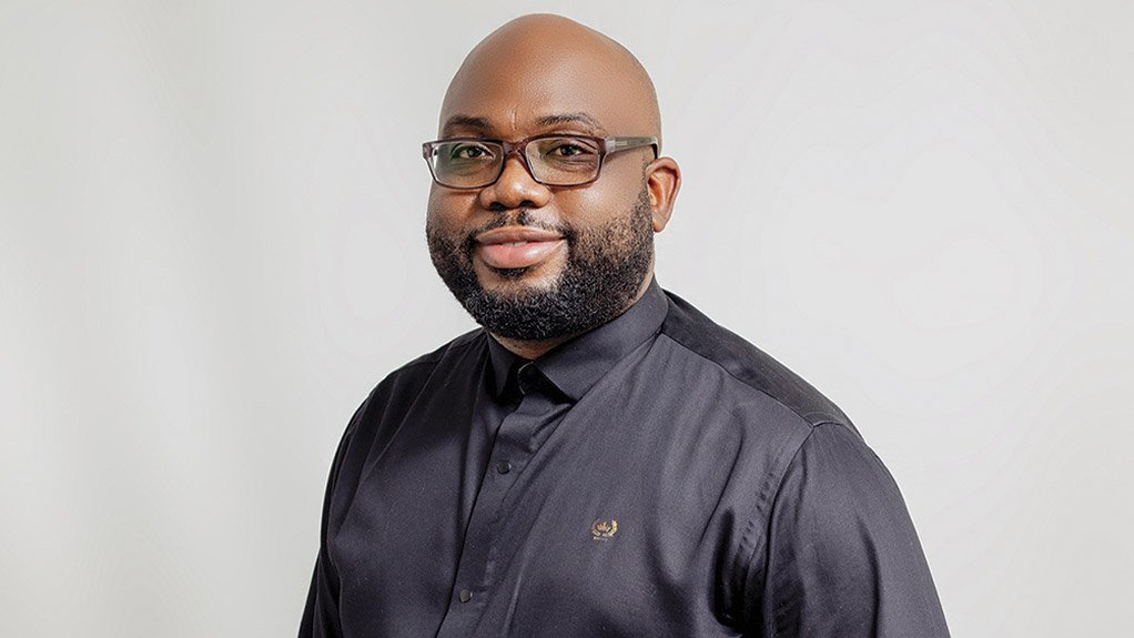 Francis Masaba smiling in navy shirt, glasses