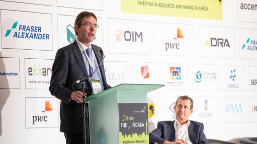 A photo of Roger Baxter speaking at an indaba podium with Bernard Swanepoel in the background.