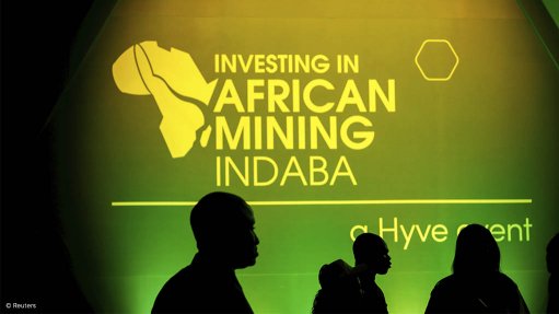 An Investing in African Mining Indaba logo displayed on a screen as delegates walk past