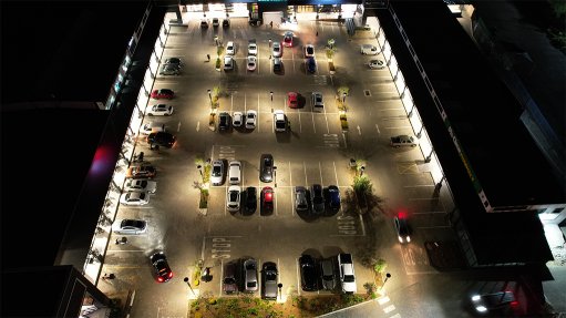 An aerial shot of the Blue Crane shopping centre at night well lit by all of the BEKA Schréder SOLARPOLE Lighting systems whch have been installed in the parking area