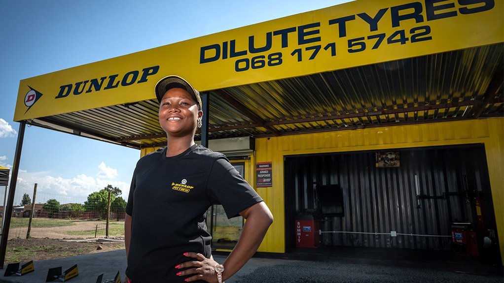 Image of a young woman standing in front of a Dunlop container