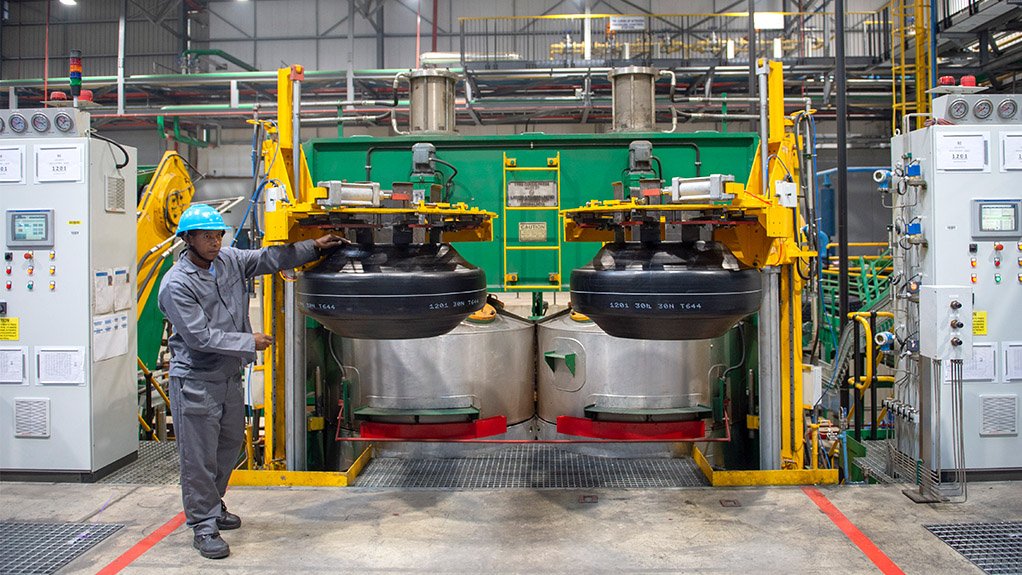 Image of a man in grey overalls at a site where truck and bus radial tyres are made