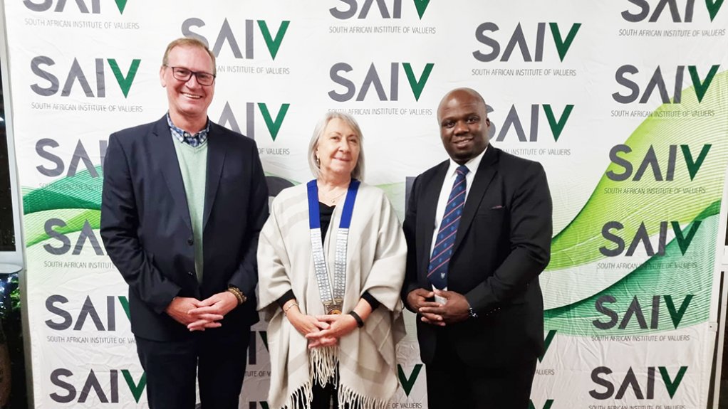Image of Patrick O'Connell, Dianne de Wet and Malusi Mthuli standing in front of the SAIV banner