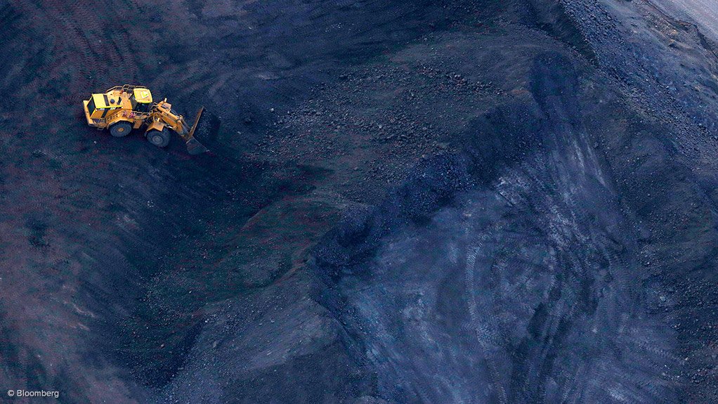 Image shows a truck on coal piles