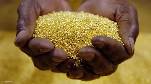 Image shows hands holding gold pellets