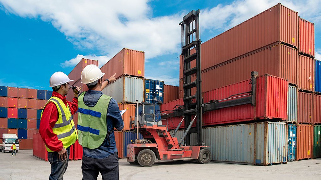 Image of two men looking at stacks of shipping containers 