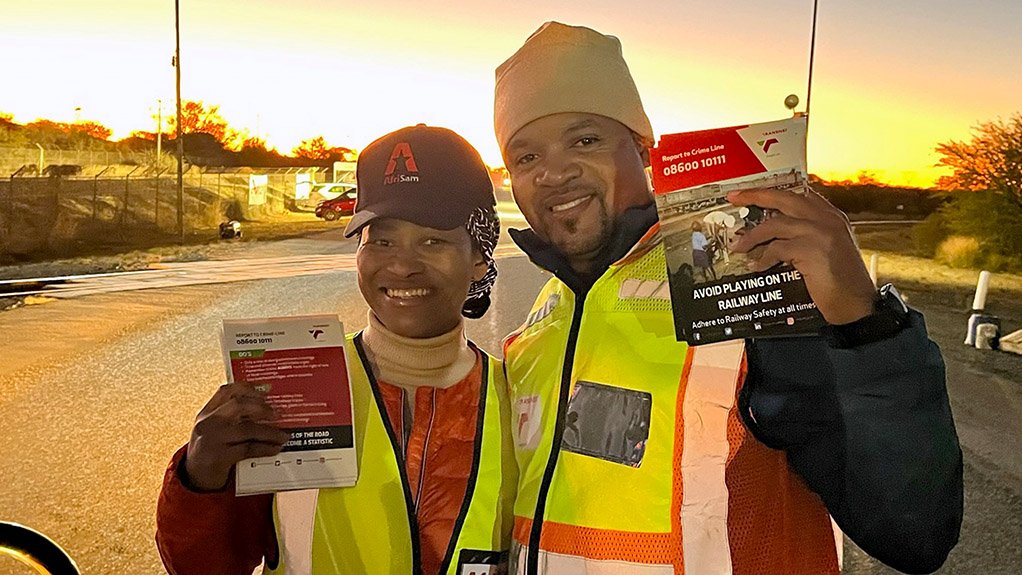 Image of two people wearing reflector vests to show AfriSam conducting a rail safety information campaign for motorists and pedestrians
