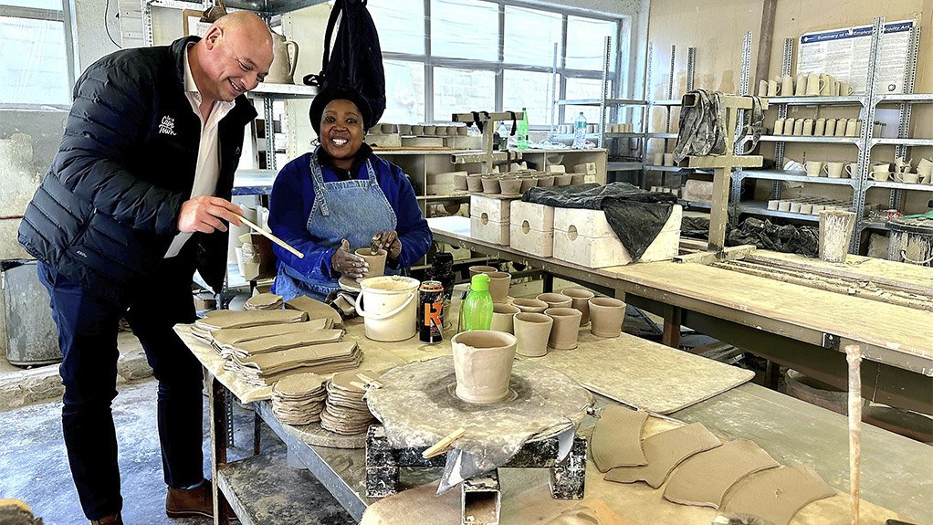 Image of Alderman James Vos, Mayoral Committee Member for Economic Growth learns a few tricks of the trade with Beauty Dumisana of Mervyn Gers Ceramics